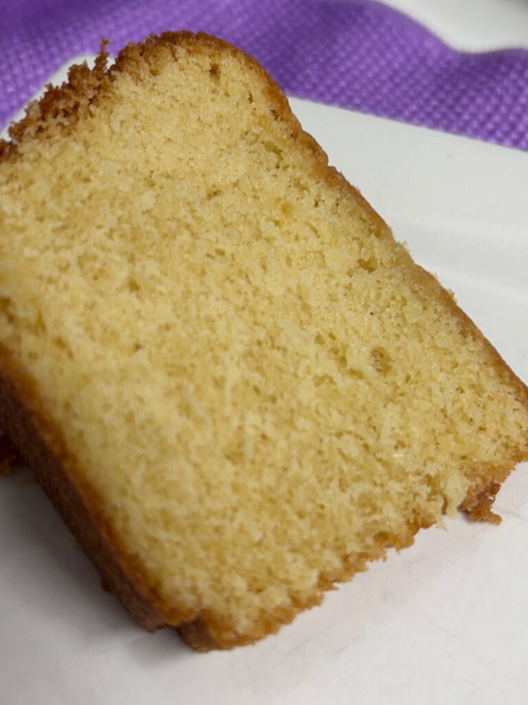 a slice of almond rum pound cake on a white plate.