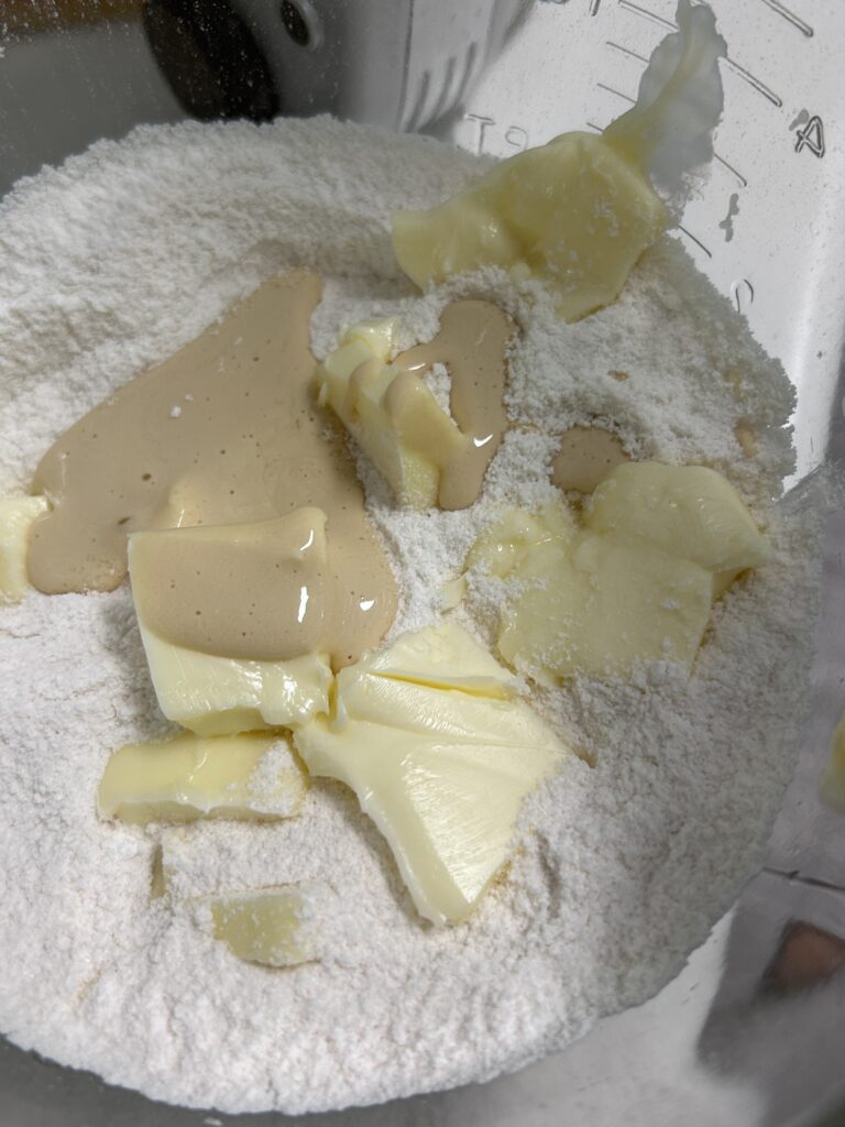 flour butter and sour cream mix in a metal mixing bowl.