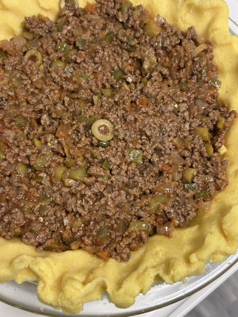 ground beef pie filling in a plolenta crust ready to bake. 