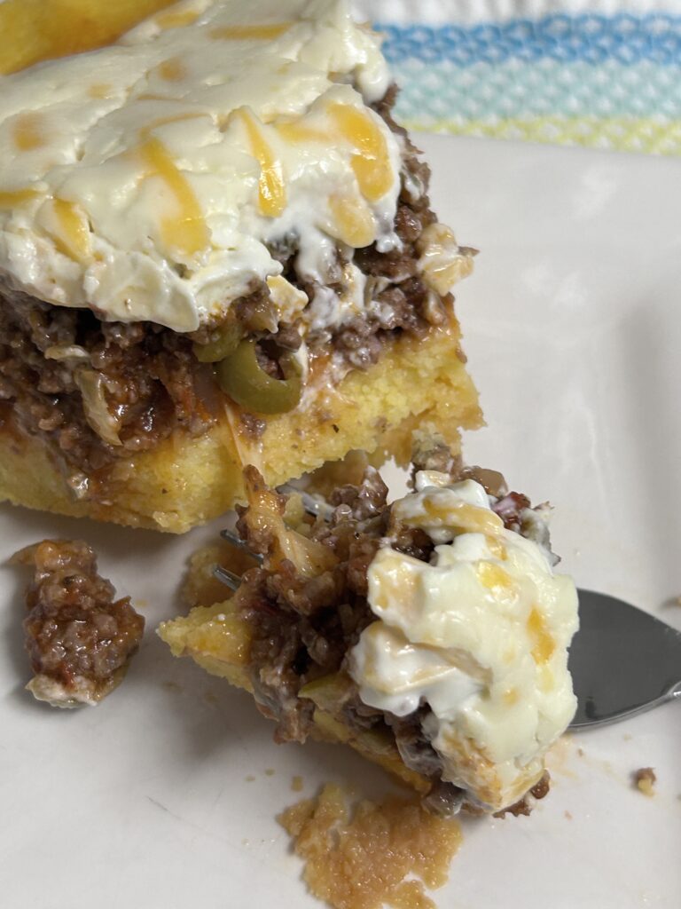 a slice of half-eaten Venezuelan  Cornmeal Beef Pie on a white plate.