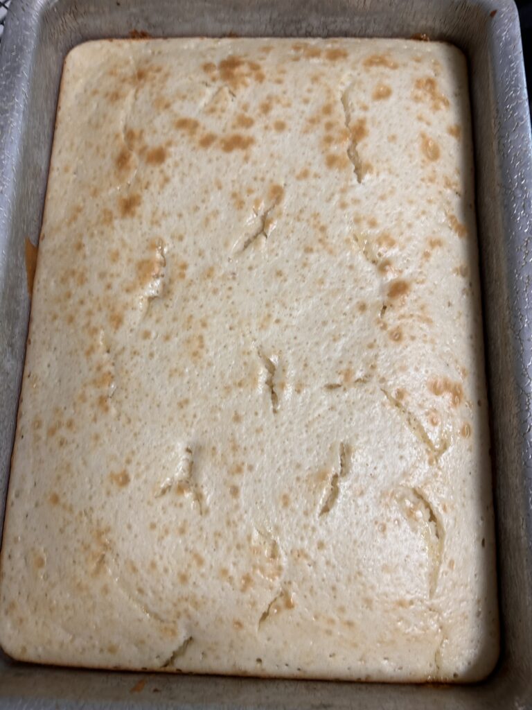 freshly baked lemon cake in a square cake pan.