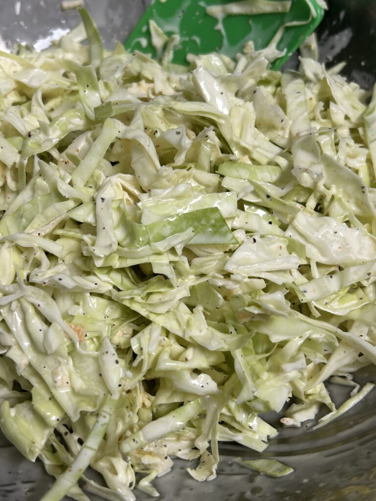 mixed creamy coleslaw in a metal bowl.