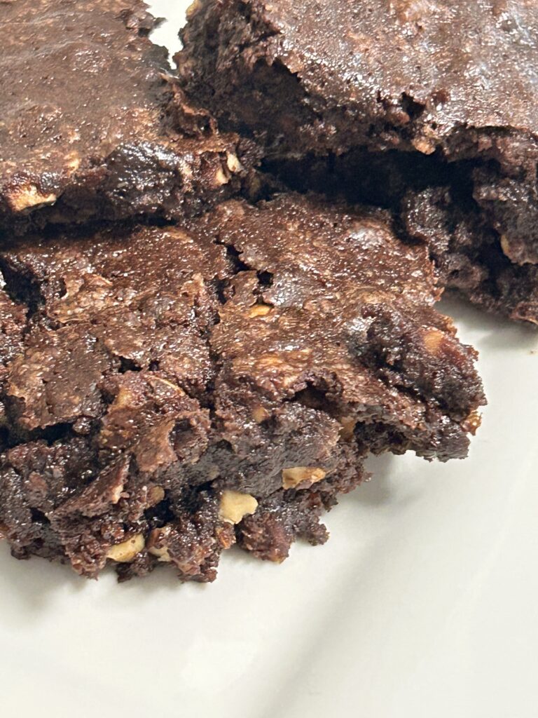 three mixed nut brownies on a white plate.