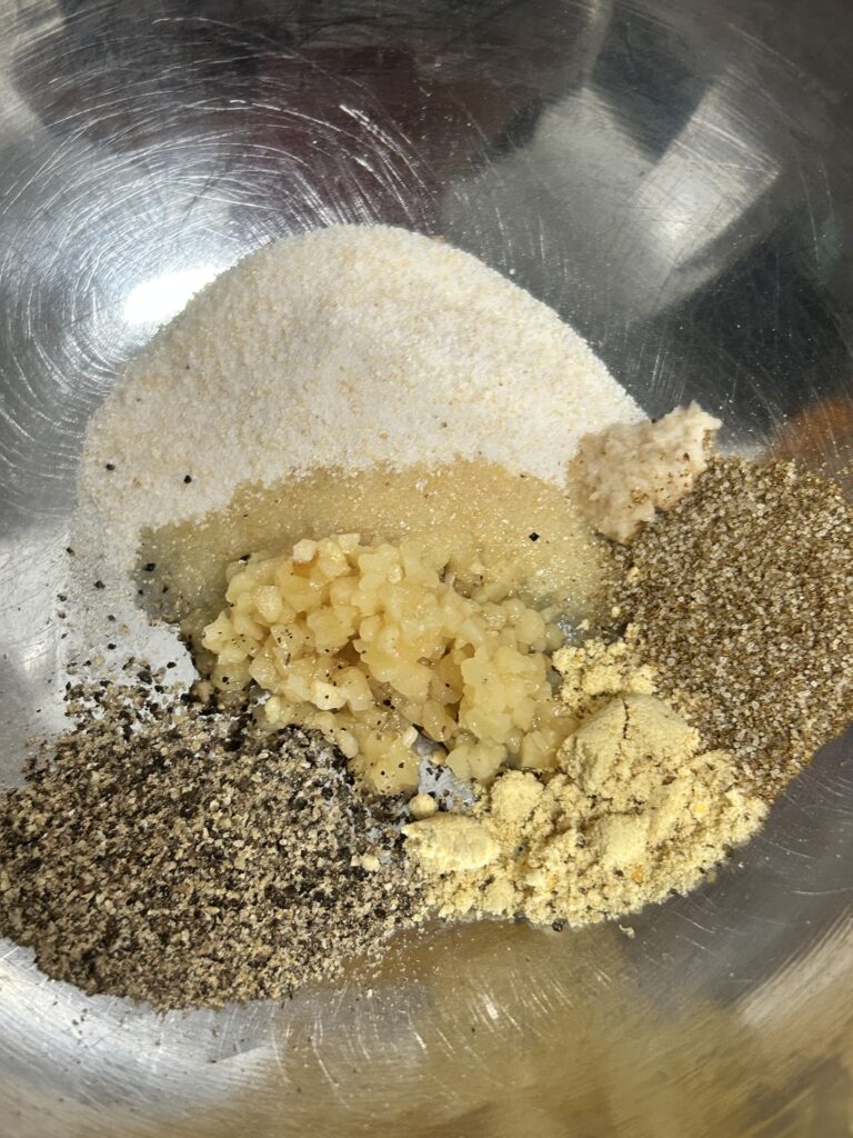 spices, minced garlic and horseradish in a metal bowl.