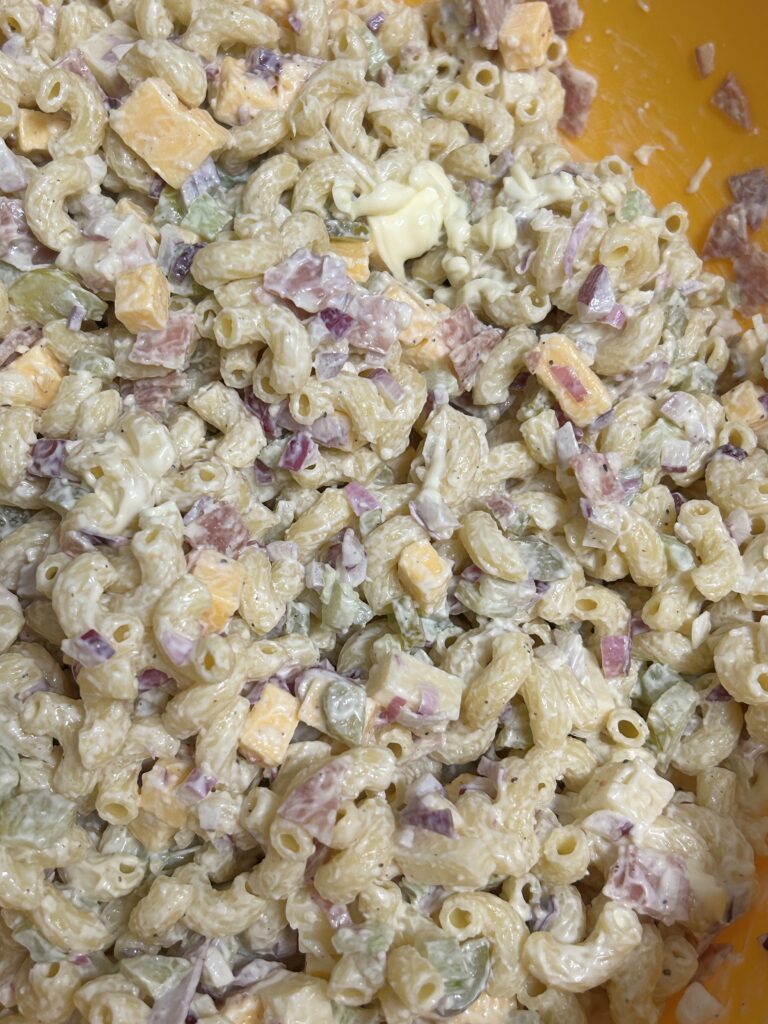 tossed macaroni pasta salad chilling in a plastic bowl.