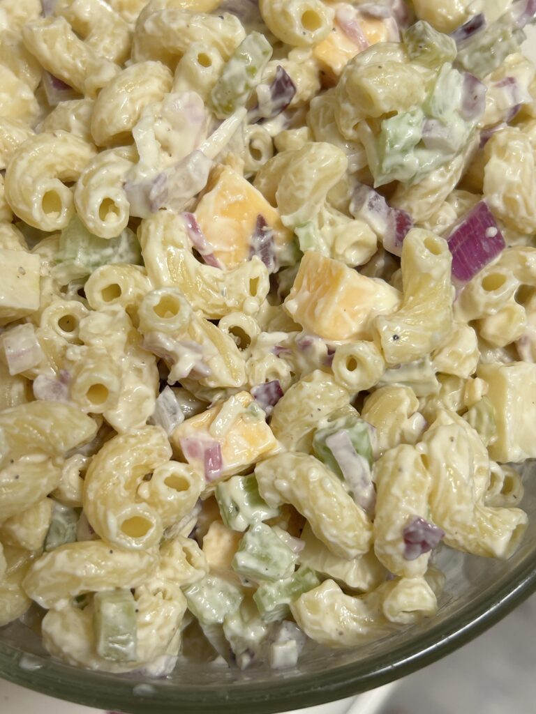 overhead shot of a bowl of chilled creamy macaroni salad in a metal bowl.
