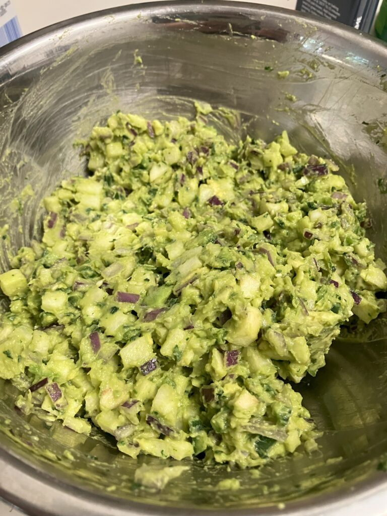 freshly made guacamole in a metal bowl. 